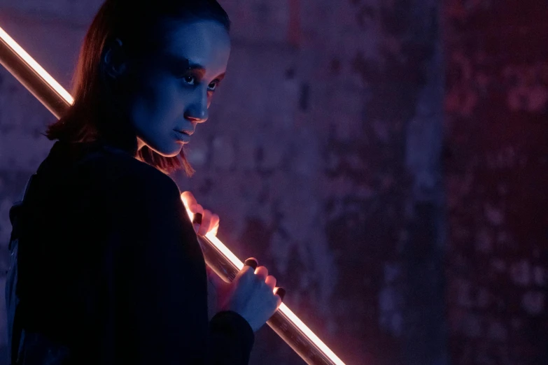 a woman holding a baseball bat in a dark room, an album cover, by Adam Marczyński, pexels contest winner, conceptual art, holding a red lightsaber, pink and orange neon lights, ariana grande as a sith, profile picture 1024px