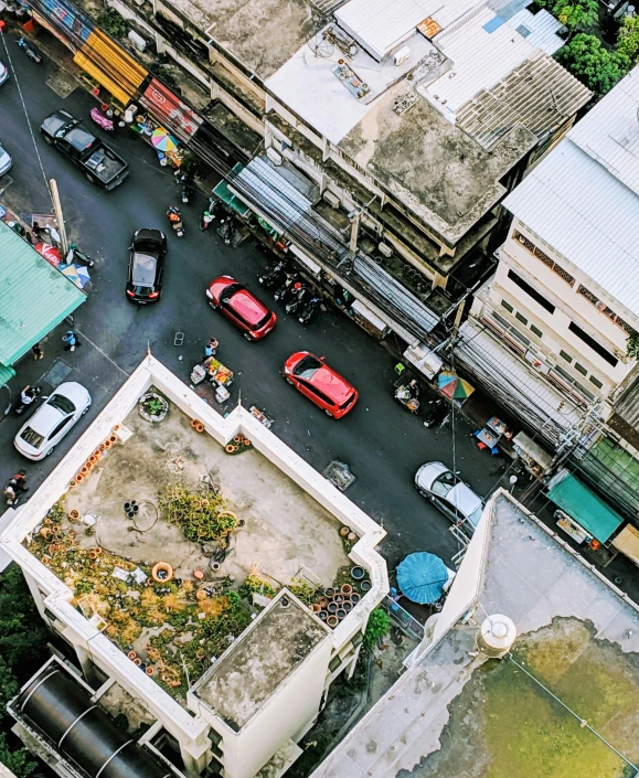 a street filled with lots of traffic next to tall buildings, trending on unsplash, bird\'s eye view, bangkok, square, a quaint