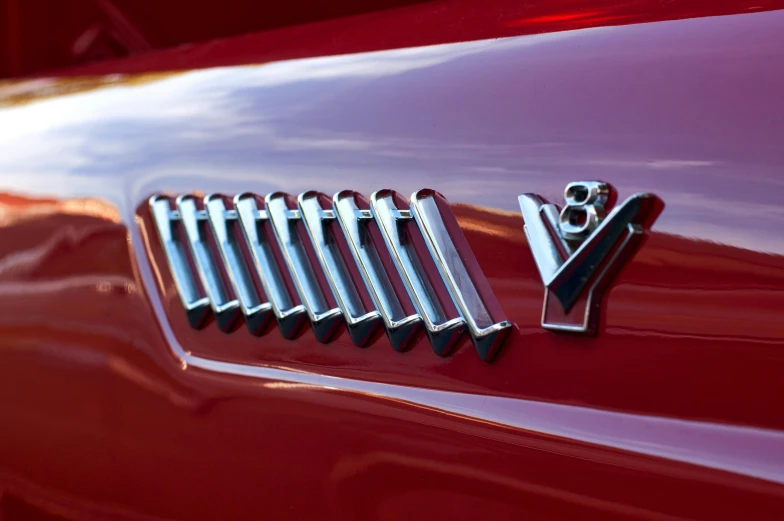 a close up of the emblem on a red car, an album cover, by Jeffrey Smith, unsplash, cobra, the last v 8 interceptor, chrome tubes, spiky, lynn varley