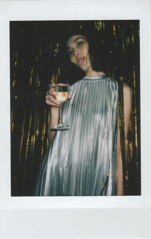 a woman in a silver dress holding a wine glass, a polaroid photo, inspired by Nan Goldin, unsplash, scanned in, parties, nishihara isao, digital image