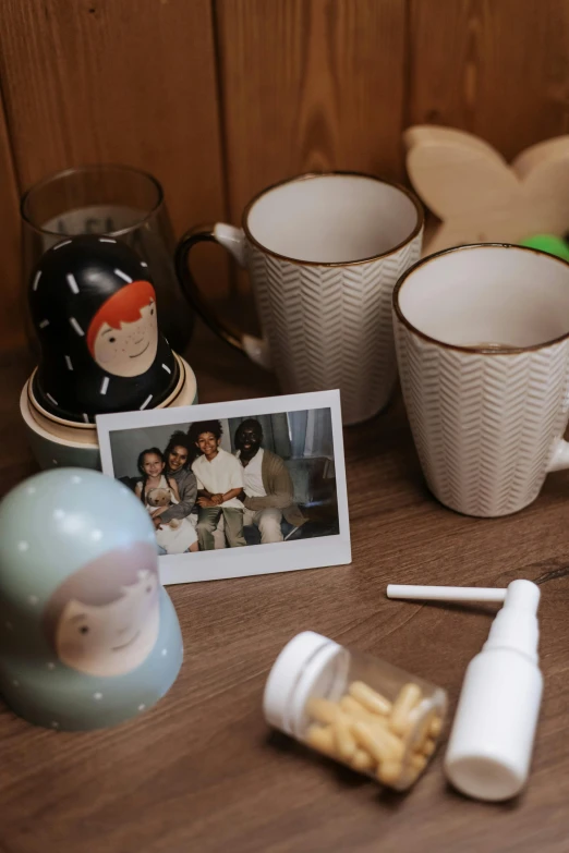 a couple of cups sitting on top of a wooden table, a polaroid photo, toys, a group of people, cottagecore, detailed product image