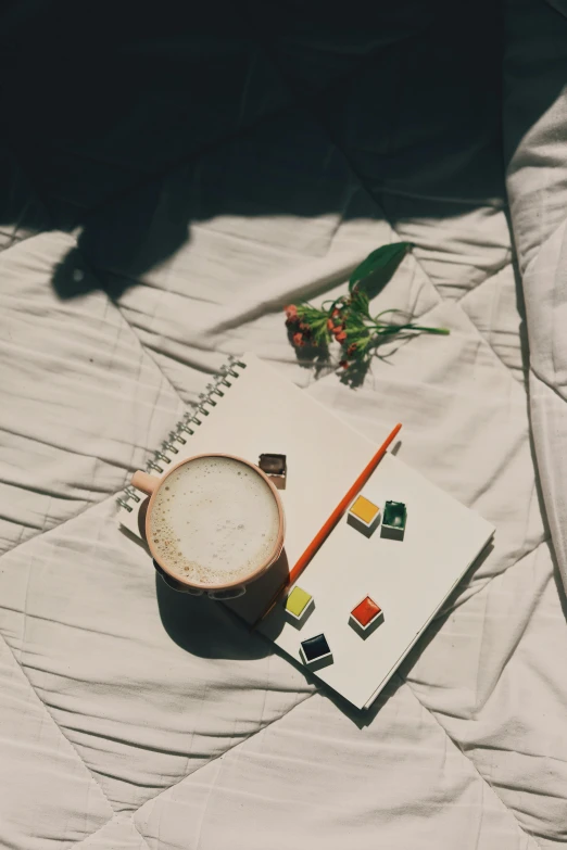 a cup of coffee sitting on top of a bed, analytical art, a rubik's cube, writing in journal, shot onfilm, high quality image