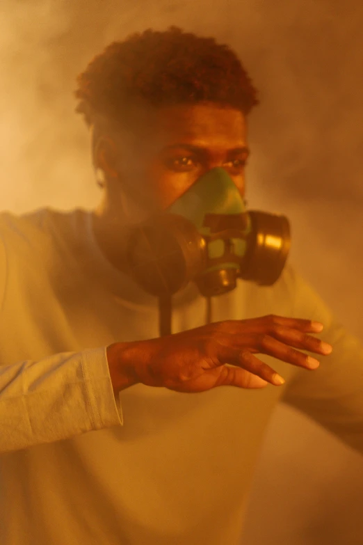a man wearing a gas mask in a smoke filled room, 2 1 savage, magic special effects, with a yellow green smog sky, ( ( theatrical ) )