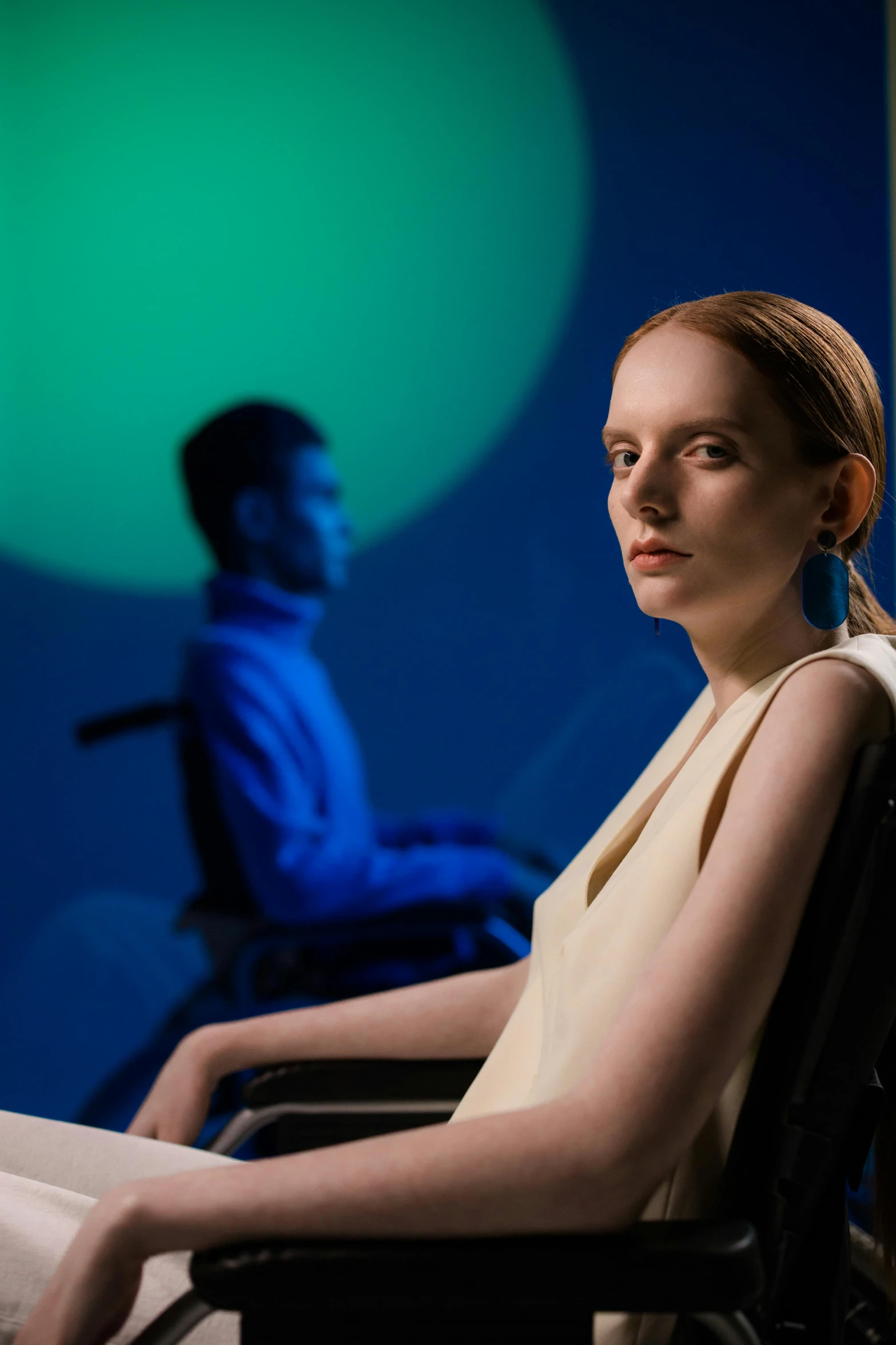 a woman sitting in a wheel chair in front of a man, inspired by Juan O'Gorman, soft volumetric lights, production photo, uncanny valley, ignant