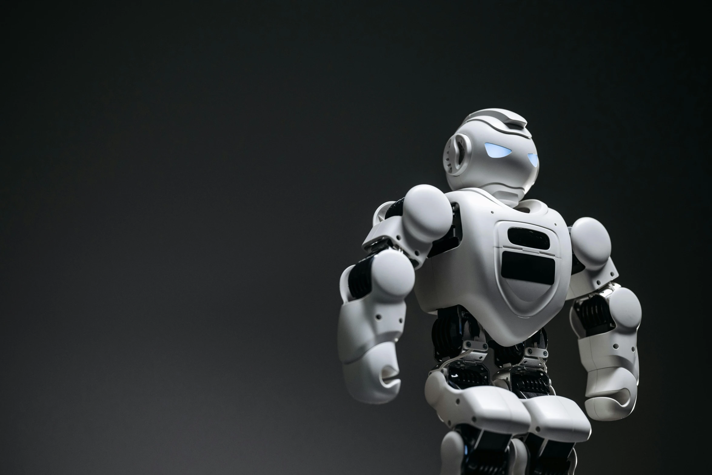 a white robot standing in front of a black background, a 3D render, by Adam Marczyński, shutterstock, on a gray background, round robot, 15081959 21121991 01012000 4k