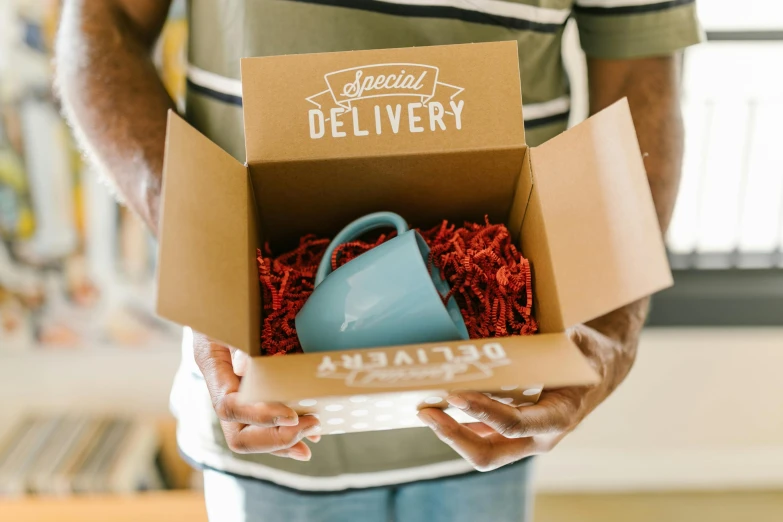 a man holding a blue watering can in a box, pexels, hurufiyya, with a white mug, logo for lunch delivery, fully decorated, thumbnail