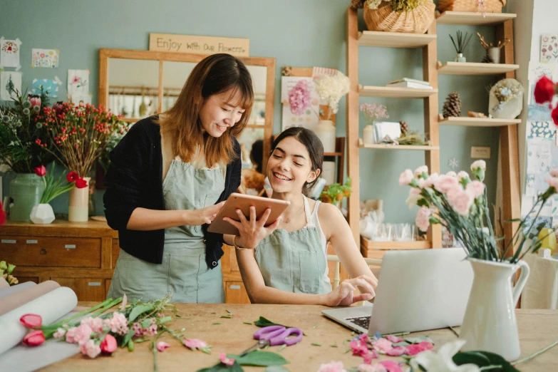two women working on a laptop in a flower shop, a photo, trending on pexels, art nouveau, avatar image, cindy avelino, full body image