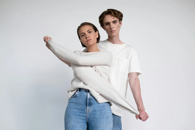 a man and a woman standing next to each other, an album cover, by Matthias Stom, pexels contest winner, wearing a white sweater, battle pose, white backround, denim