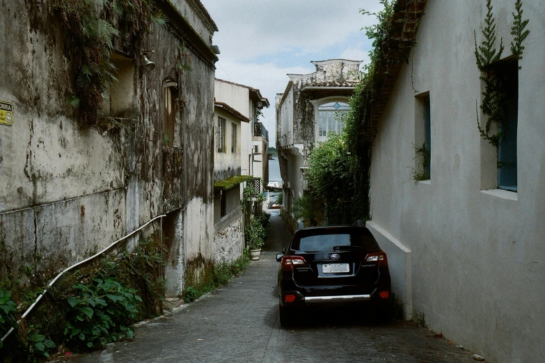 a car parked on the side of a narrow street, inspired by Thomas Struth, pexels contest winner, renaissance, on the coast, ai weiwei and gregory crewdson, pompeii, sao paulo