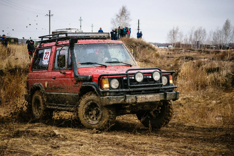 a red jeep driving through a muddy field, by Adam Marczyński, pexels contest winner, russian lada car, in a race competition, 🚿🗝📝