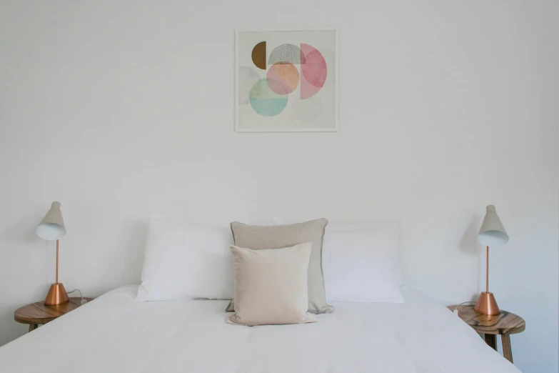 a white bed room with a neatly made bed, a minimalist painting, inspired by Agnes Martin, trending on unsplash, visual art, lots of pastel colour, light beige pillows, detail shot, full product shot