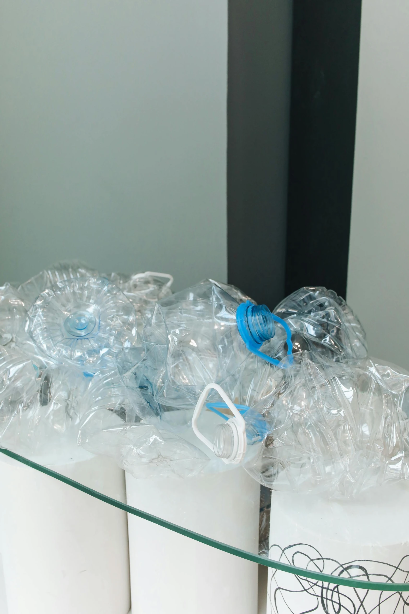 a bunch of plastic bottles sitting on top of a glass table, masks, an upside down urinal, profile image, light blues