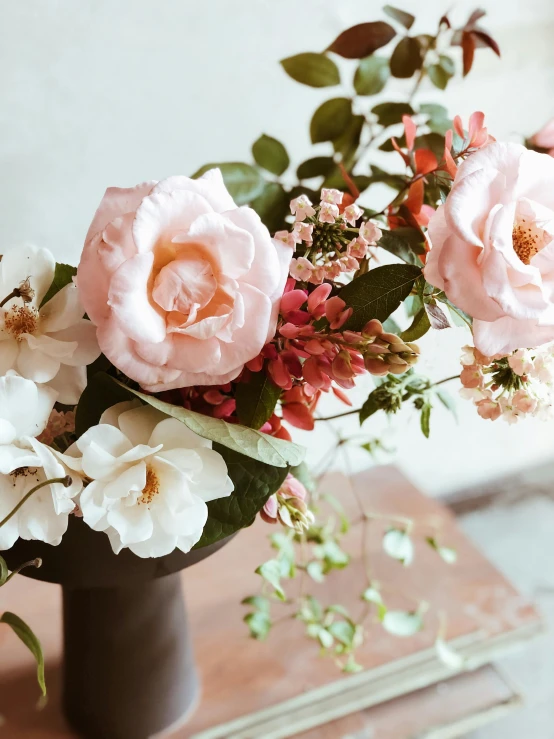 a vase filled with pink and white flowers, inspired by Rose O’Neill, trending on unsplash, lush plant and magical details, medium close up, brown flowers, detailed product shot