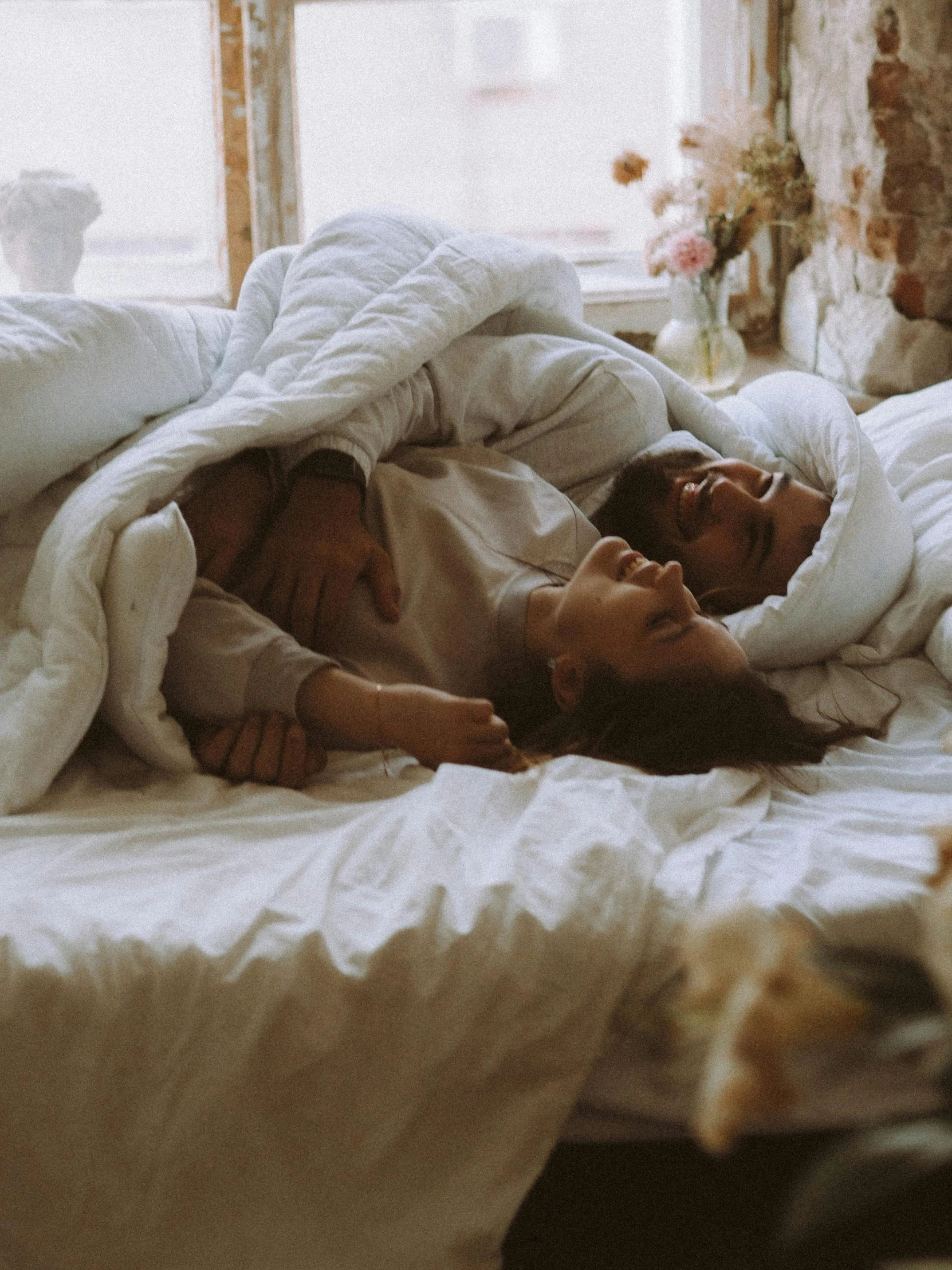 a couple of people laying on top of a bed, pexels contest winner, romanticism, wearing simple robes, profile image, sleeping bag, hugging each other