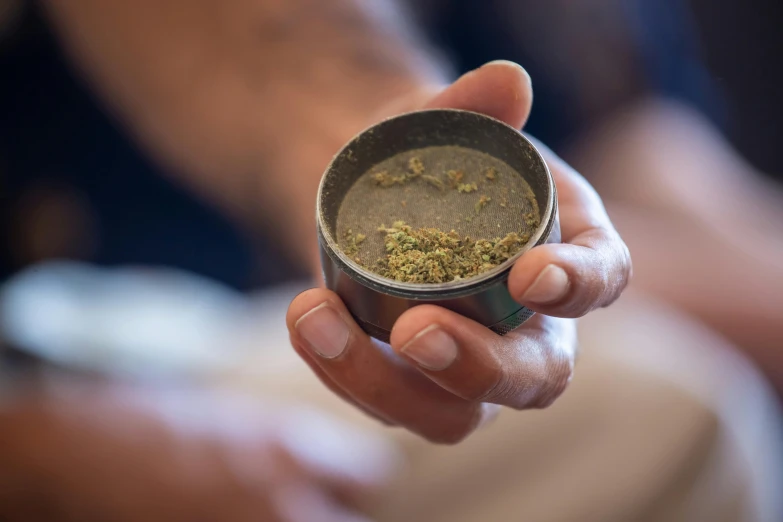 a close up of a person holding a cup of coffee, ganja, lachlan bailey, trimmed, ashtray