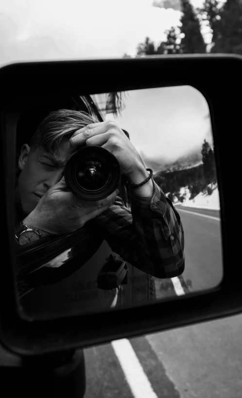 a man taking a picture of himself in a rear view mirror, a black and white photo, hasselblad medium format camera, filmstill, caspar david, journalist photo