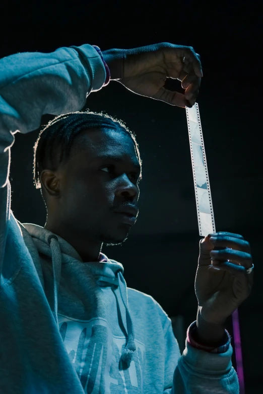 a man holding a tennis racquet in one hand and a tennis ball in the other, an album cover, trending on pexels, chief keef, perfectly lit. movie still, holding a syringe!!, low light cinematic