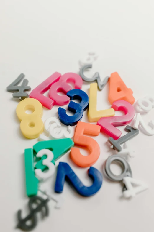 a pile of letters sitting on top of a table, plastic toy, numerical, curated collections, multicolor