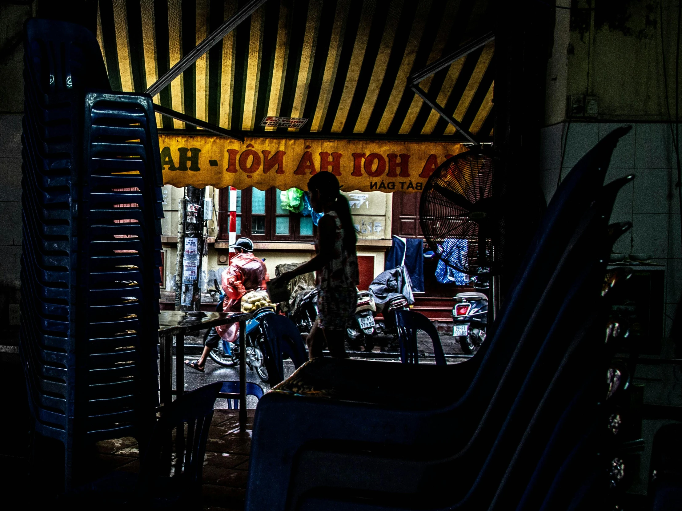 a couple of people standing in front of a store, by Julia Pishtar, unsplash contest winner, vietnam, dimly lit dive bar, people outside eating meals, shady alleys