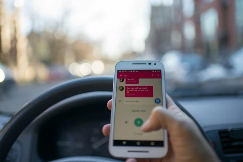 a person holding a cell phone while driving a car, pexels, happening, square, gradient yellow to red, messages, from street level