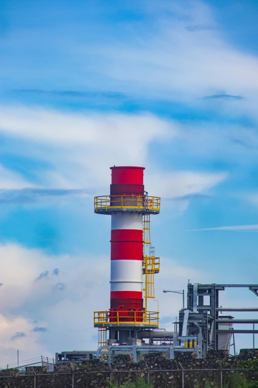 a red and white lighthouse sitting on top of a hill, industrial pipes, profile image, petrol energy, blue