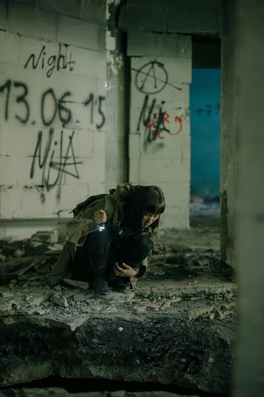 a person kneeling down in a room with graffiti on the walls, postapocalyptic, cinematic still, injured, cinematic lut