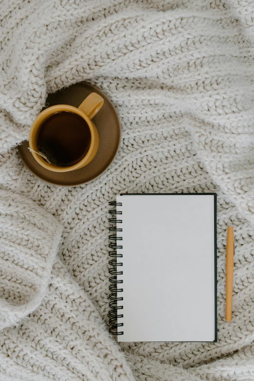 a cup of coffee and a notebook on a bed, by Carey Morris, pexels contest winner, minimalism, brown sweater, thumbnail, pencil and paper, 15081959 21121991 01012000 4k