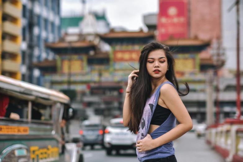 a woman standing in the middle of a city street, pexels contest winner, beautiful young himalayan woman, wearing a tanktop, malaysian, mongolia