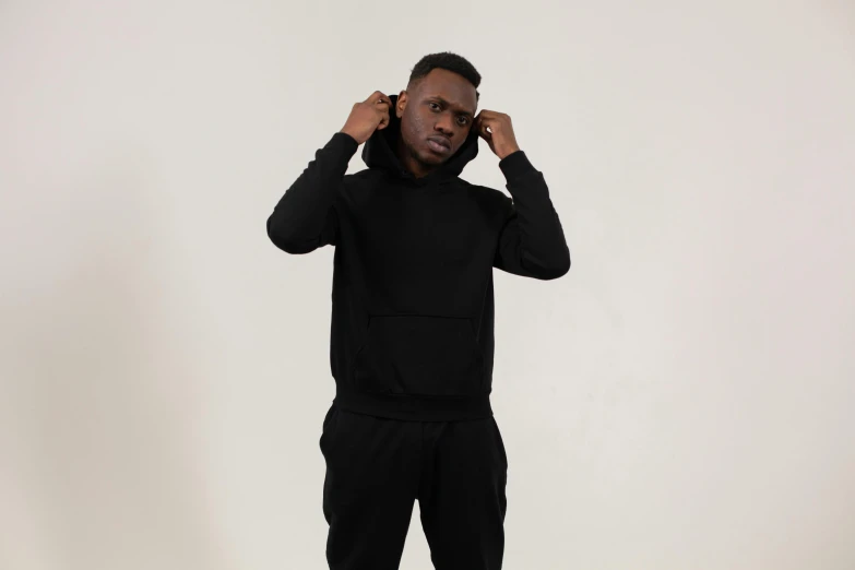 a man in a black hoodie poses for a picture, unsplash, tracksuit, 8ft tall, mkbhd, front