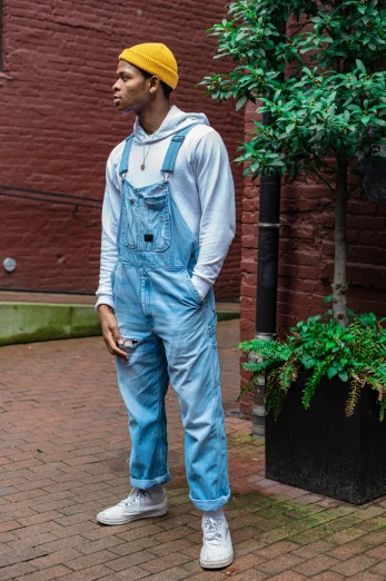 a man standing in front of a brick building, wearing blue jean overalls, designed for cozy aesthetics!, ashteroth, off - white collection