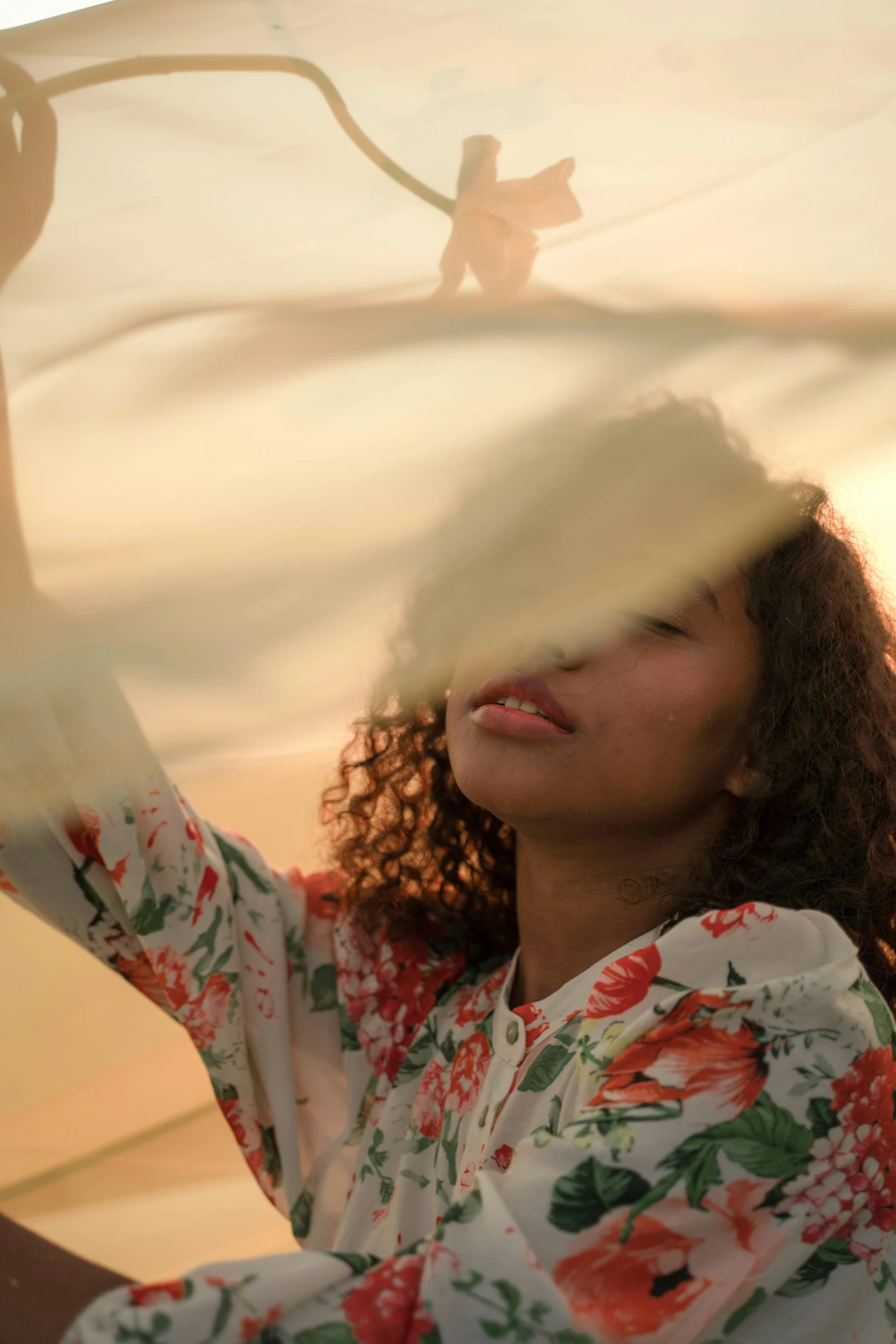 a woman holding an umbrella over her head, a picture, trending on unsplash, arabesque, golden hour 8 k, wavy hair spread out, imaan hammam, white cloth in wind shining