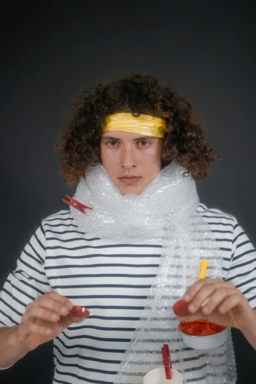 a man in a striped shirt holding a bottle of ketchup, an album cover, inspired by Julius Klinger, plasticien, glass bubble helmet, timothee chalamet, covered in bandages, mid 2 0's female