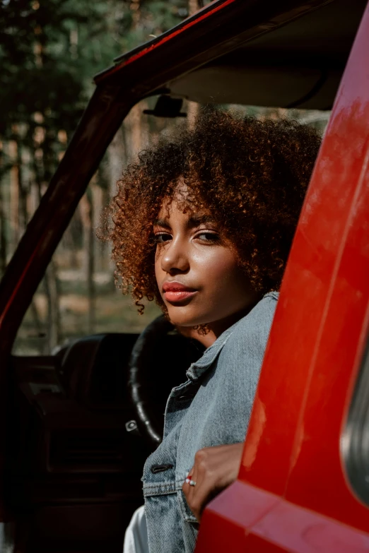 a woman sitting in the driver's seat of a red truck, pexels contest winner, renaissance, curly afro, she has olive brown skin, handsome girl, square