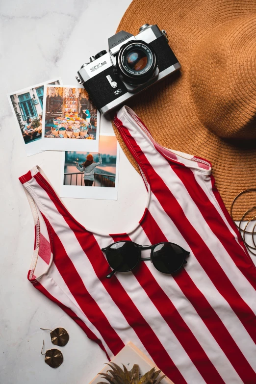 a hat, sunglasses and a camera on a table, pexels contest winner, red and white stripes, wearing : tanktop, holiday, female outfit