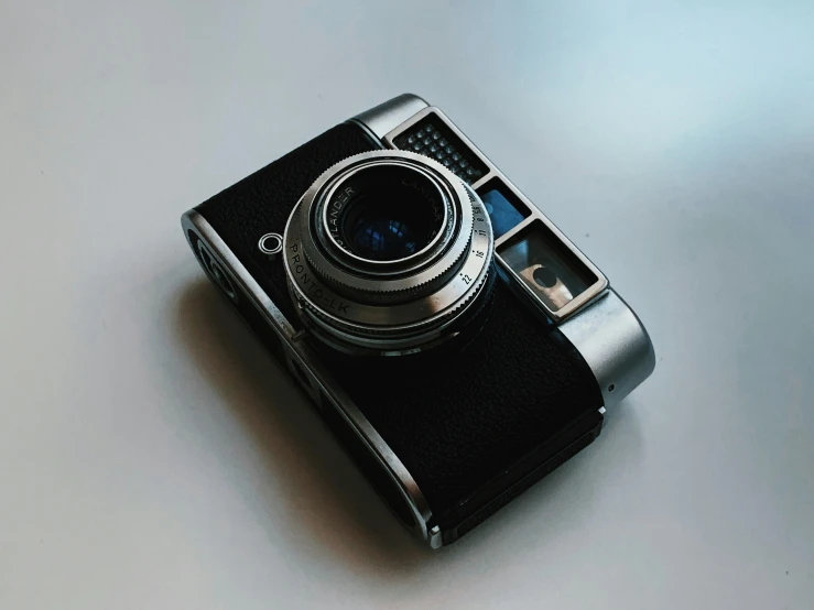 a close up of a camera on a table, on a gray background, posing for a picture, instagram post, camera obscura