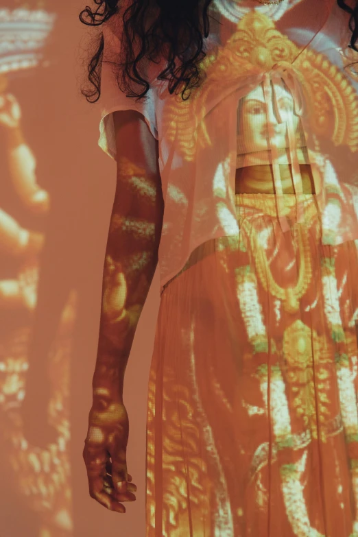 a woman that is standing in front of a wall, inspired by Anna Füssli, holography, hindu god, closeup of arms, dye - transfer, wearing light