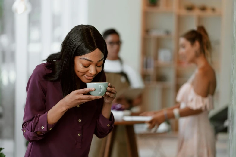 a woman standing in a kitchen holding a cup of coffee, pexels contest winner, happening, enjoying coffee at a coffee shop, avatar image, diverse, people at work