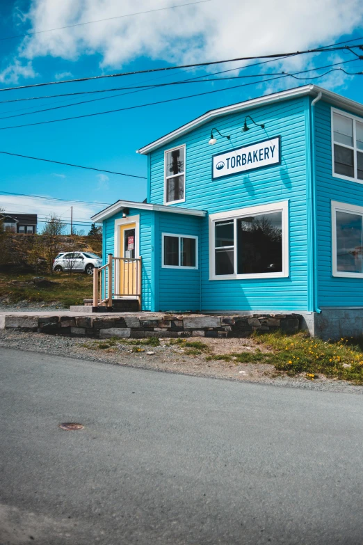 a blue building sitting on the side of a road, bakery, totorrl, views to the ocean, sk