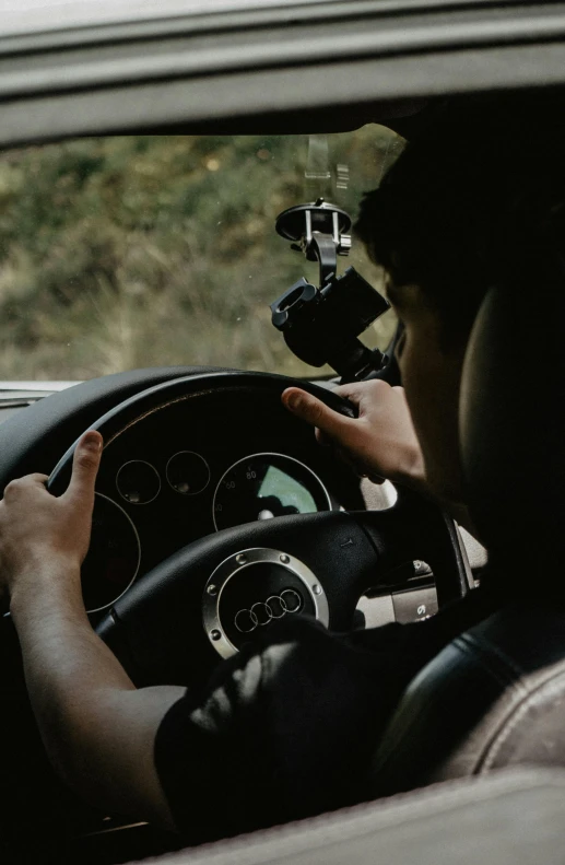 a man driving a car with his hand on the steering wheel, a picture, unsplash, visual art, taken on go pro hero8, transparent black windshield, lost footage, looking off to the side