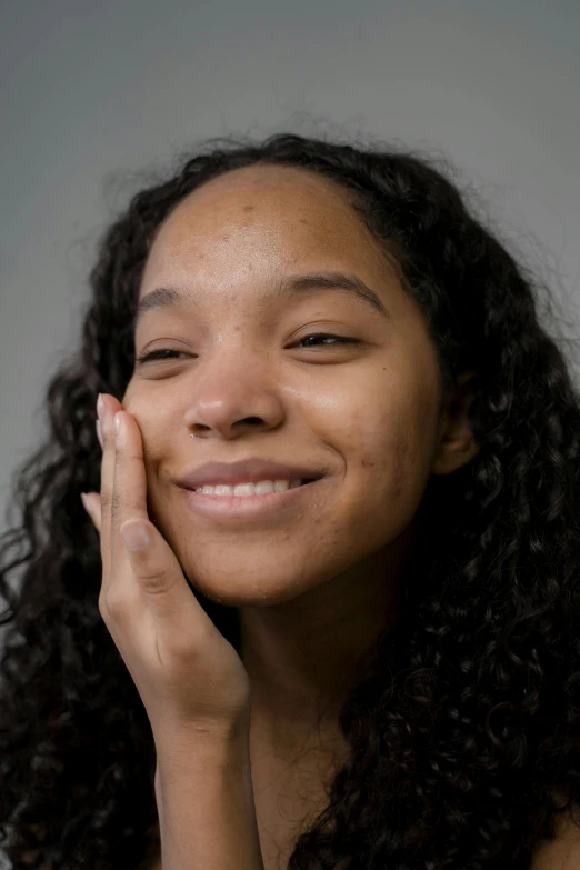 a close up of a person with a tooth brush, black scars on her face, satisfied pose, hand on cheek, no makeup wavy hair