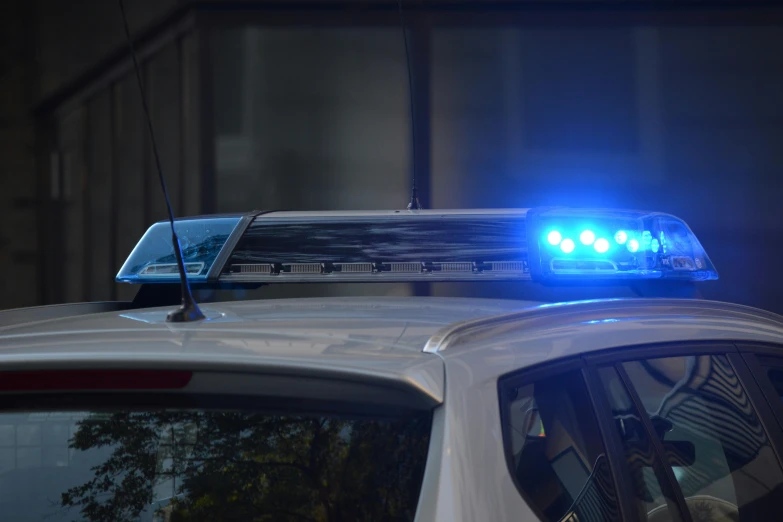 a police car with its lights on at night, unsplash, photorealism, with a roof rack, blue backlight, high quality photo, high resolution image