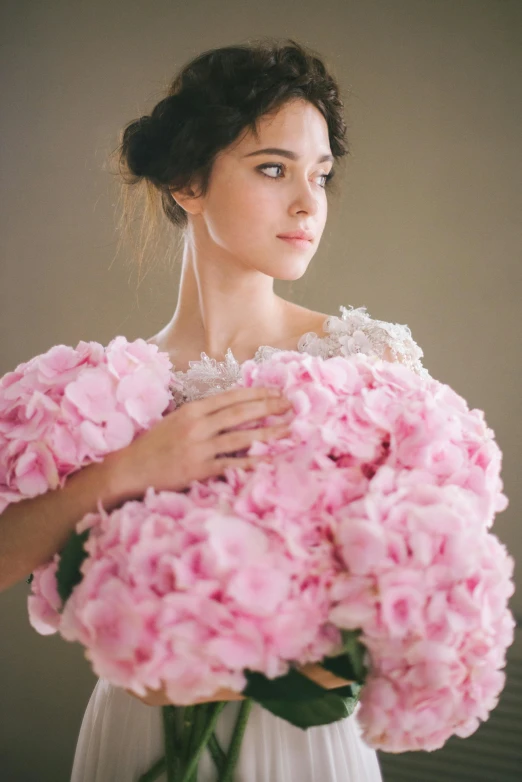 a woman holding a bouquet of pink flowers, inspired by Oleg Oprisco, medium - shot, gown, hydrangea, upclose