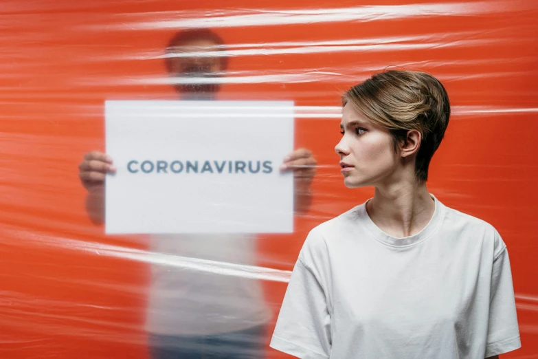 a man holding a sign that says coronavirus, an album cover, by Georgina Hunt, pexels contest winner, emma watson with anxious, two still figures facing camera, seen from the side, blank