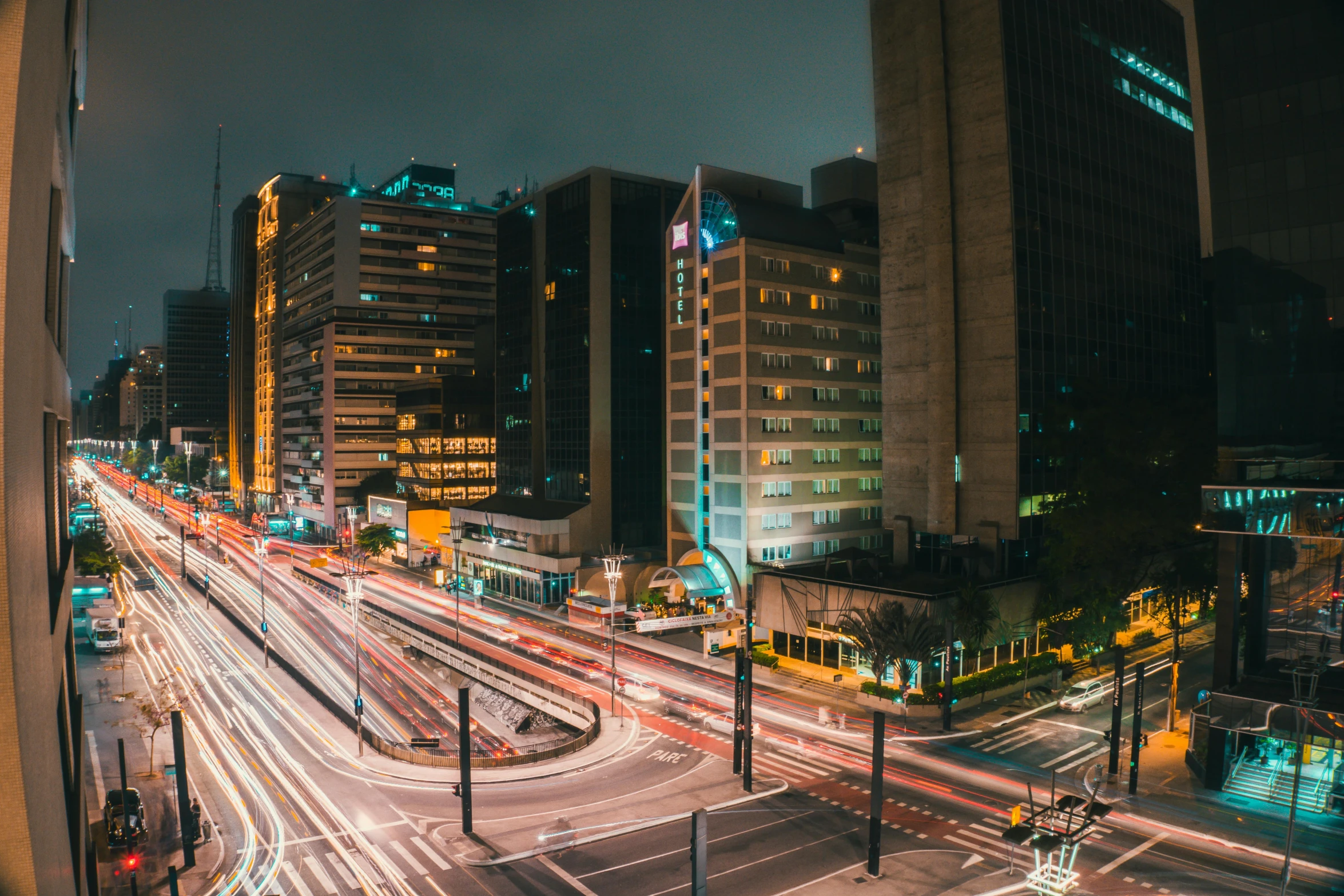 a city street filled with lots of traffic next to tall buildings, by Felipe Seade, pexels contest winner, lines of lights, panoramic shot, gif, sao paulo