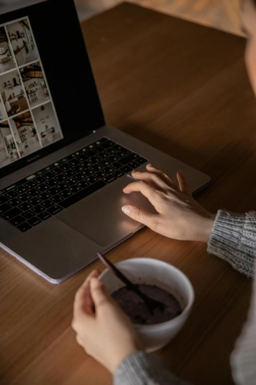 a woman sitting at a table using a laptop computer, a computer rendering, trending on pexels, cereal, dark photo, brown, with a white mug