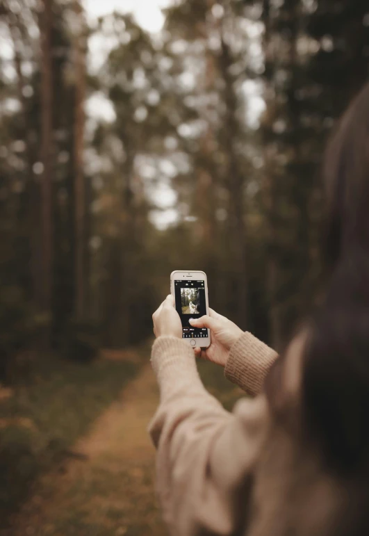 a woman taking a picture of herself in the woods, a picture, trending on unsplash, realism, pixelated, phone in hand, plain, photograph ”