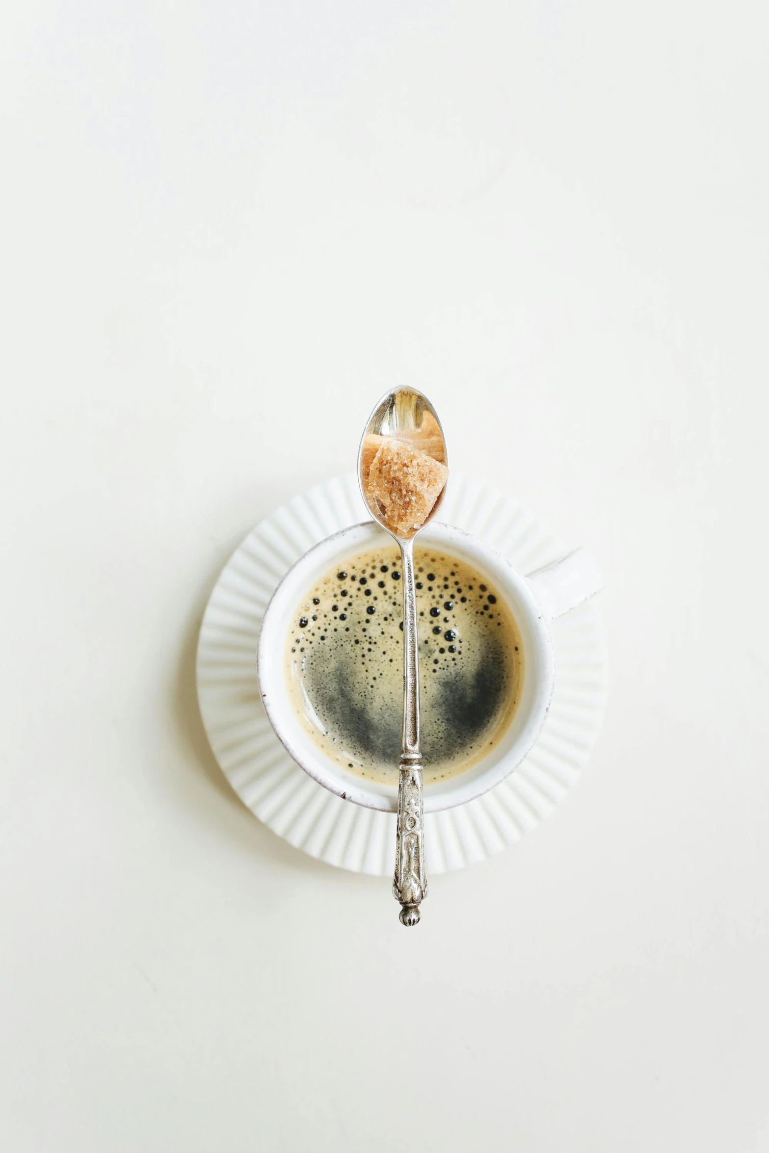 a cup of coffee with a spoon in it, by Matthias Stom, trending on unsplash, minimalism, moldy, 15081959 21121991 01012000 4k, silver light, instagram picture