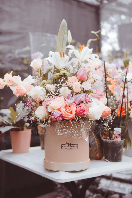 a bunch of flowers sitting on top of a table, inspired by Eden Box, romanticism, in shades of peach, commercially ready, cheerful atmosphere, the flower tower