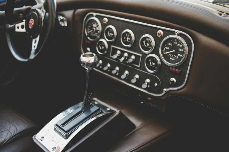 a close up of a dashboard in a car, by David Donaldson, unsplash, renaissance, vintage aston martin, fan favorite, highly detailed hyper real retro, real engine 5 cinematic