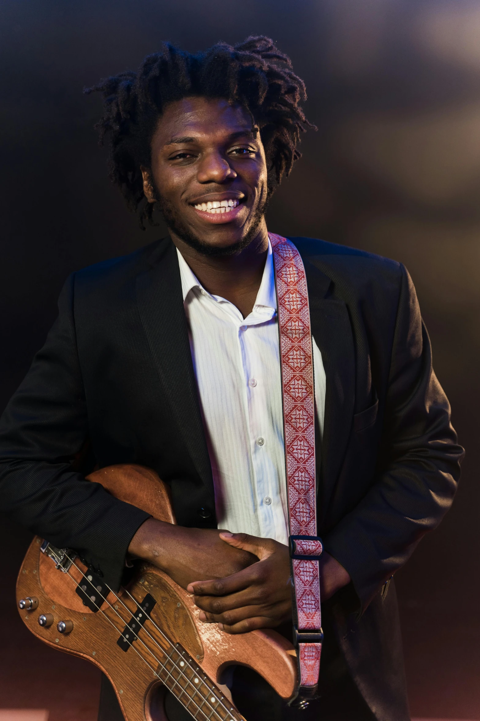 a man in a suit holding a guitar, by Willian Murai, smiling male, with brown skin, studio lit, afro tech